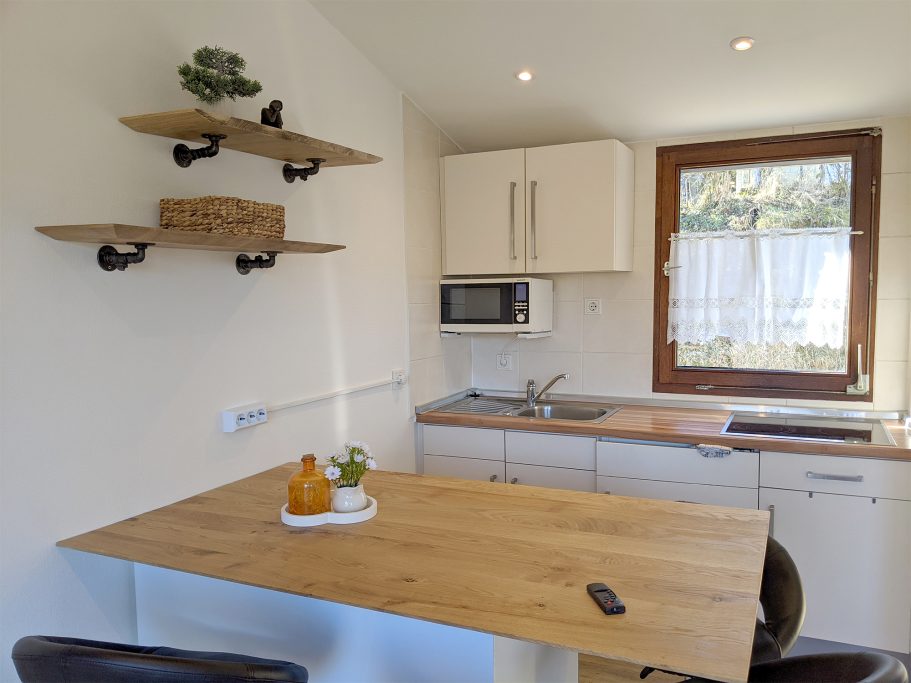 Die Küche vom Ferienhaus Helle Küche mit Holztisch, Futterholzregalen und moderner Küchenausstattung.