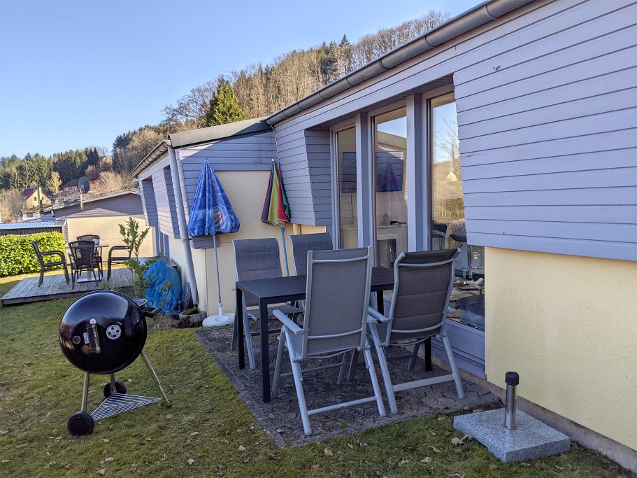 Möblierte Terrasse mit Grill Terrasse mit Gartenmöbeln, Grill und Blick auf die umliegende Landschaft.