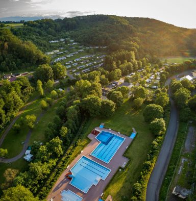 Luftaufnahme des Campingplatzes mit Schwimmbädern und umliegender Natur.
